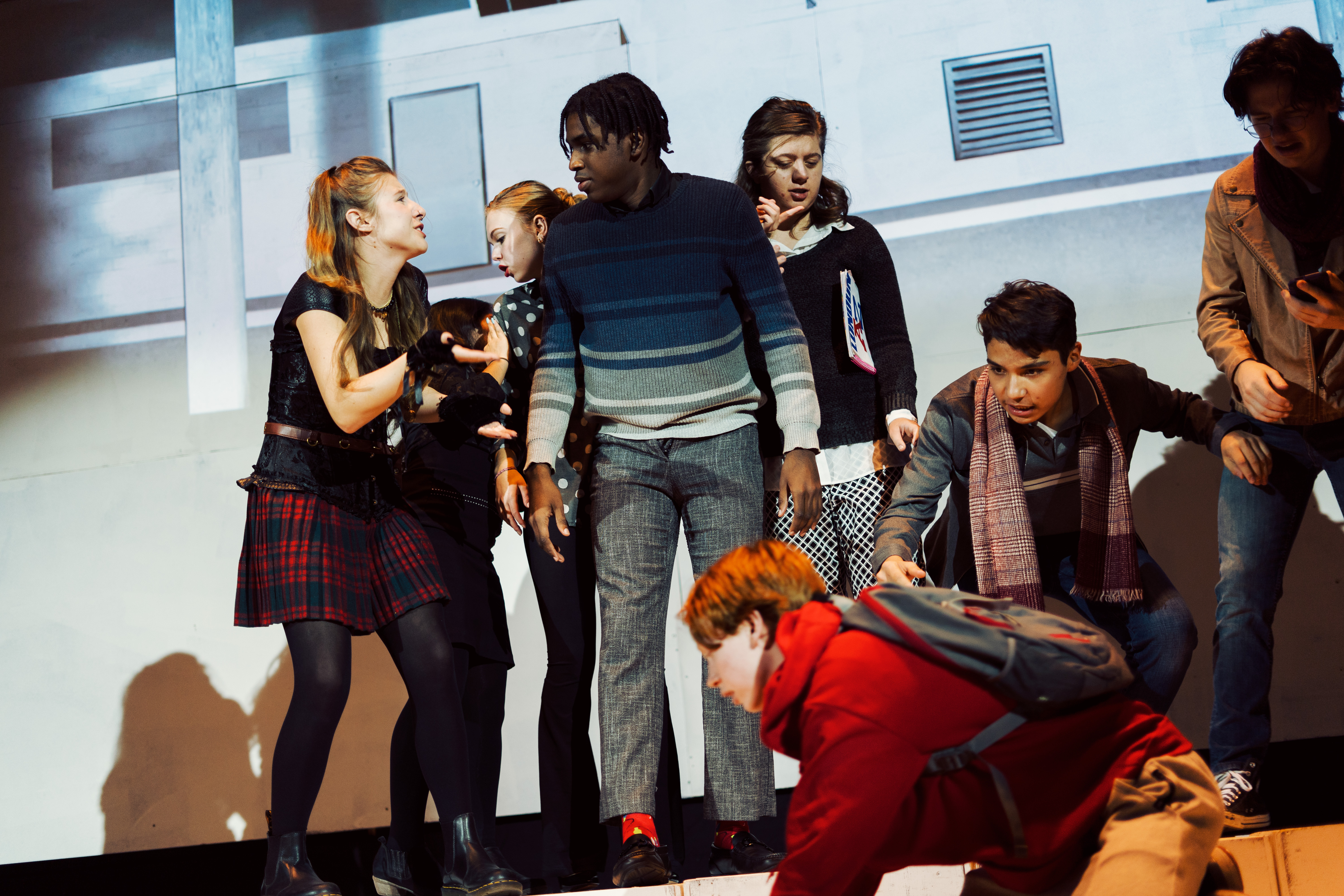 A group of teenagers acting out a scene from The Curious Incident of the Dog in the Night-Time.
